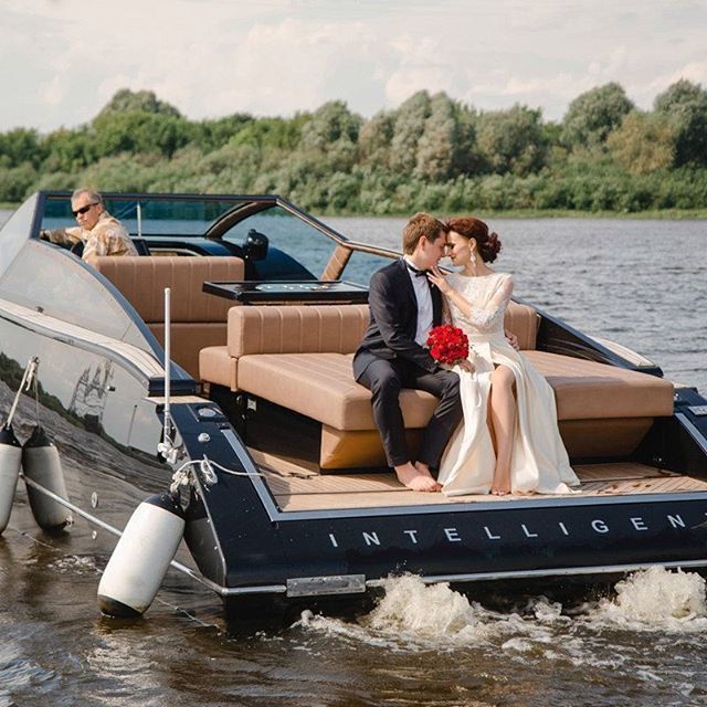 A couple on a leisure motorboat’s stern seat